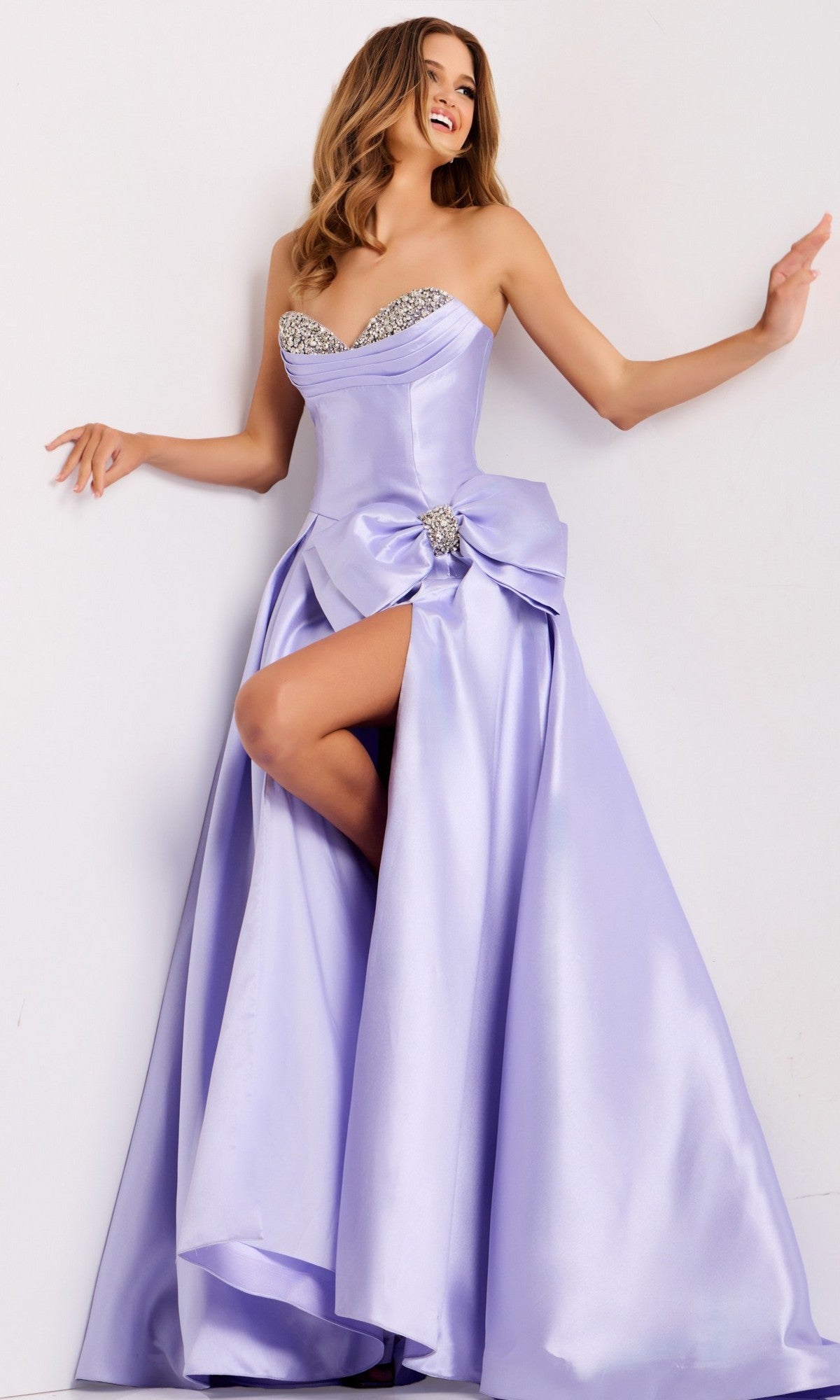 A woman showcases the Jovani 49196 long prom dress with a strapless satin design, embellished sweetheart neckline, jeweled bodice, and thigh-high slit against a plain white background.